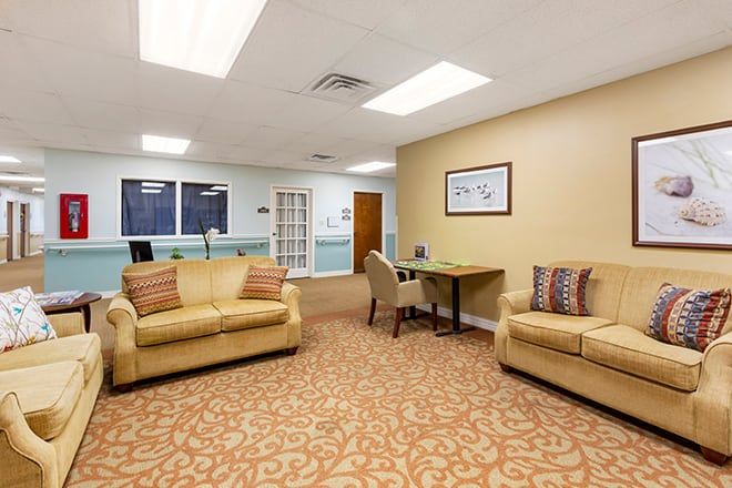 A cozy waiting room with comfortable sofas and bright lighting.