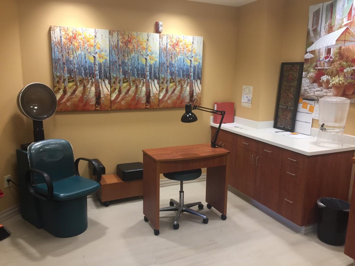 A well-appointed manicure station in a nail salon featuring modern artwork and comfortable seating.