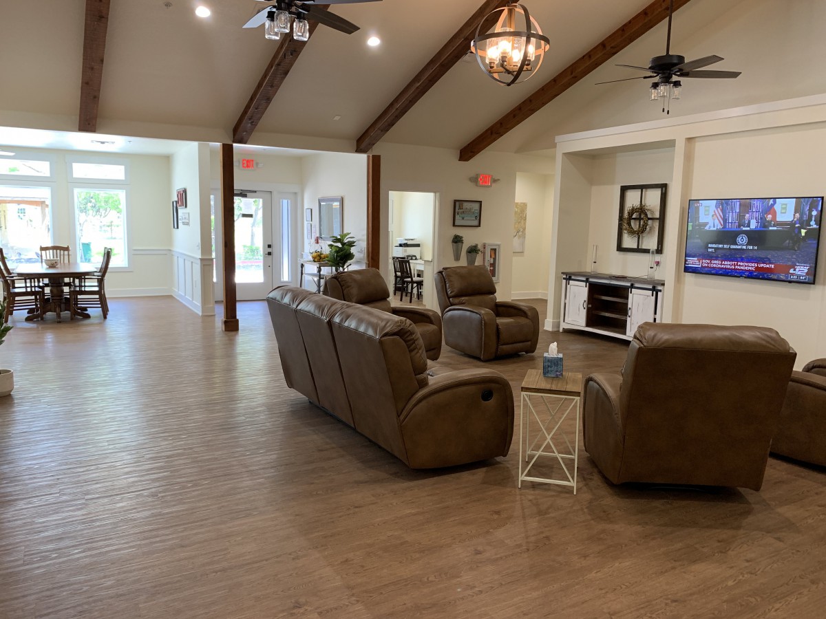 A spacious, modern living room with comfortable sofas and vaulted ceilings adorned with wood beams.