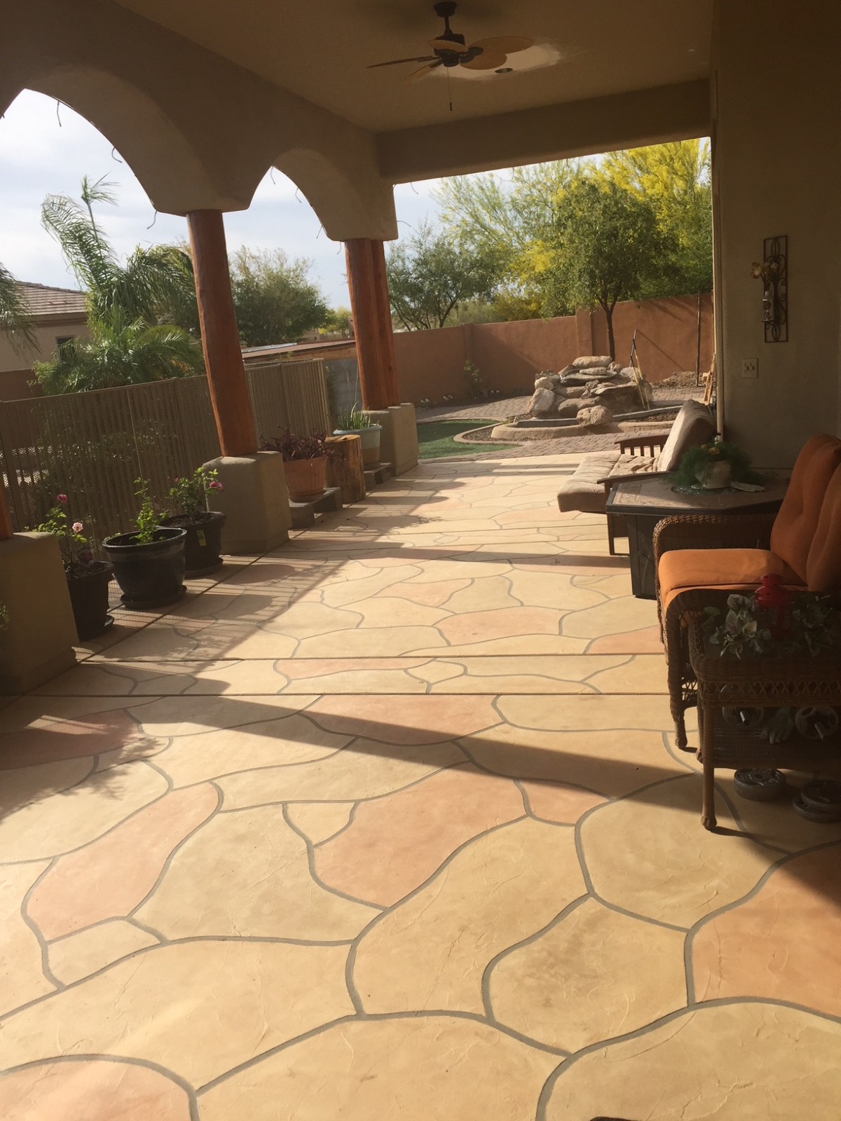 A sunny patio with comfortable seating and potted plants.