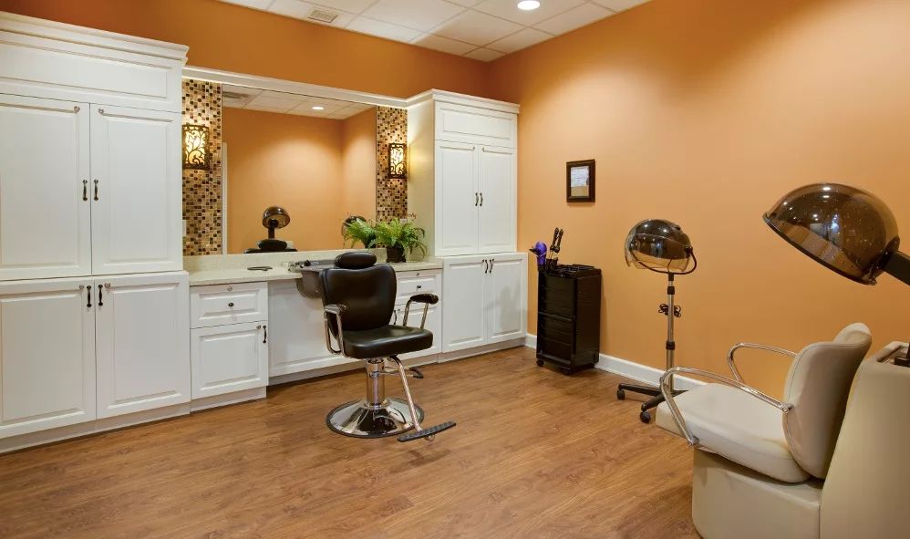 A cozy salon with a barber chair, mirror, and hair drying equipment.