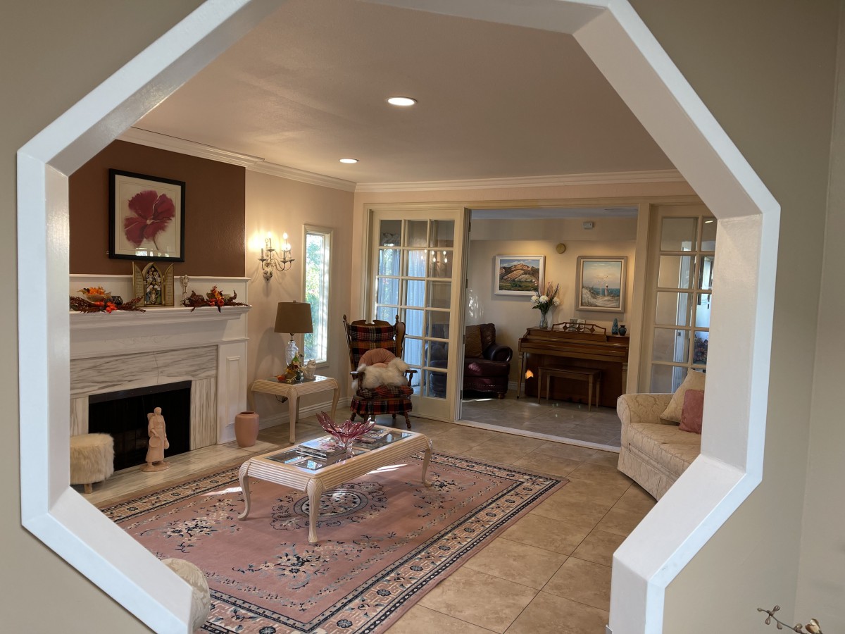 A cozy living room with elegant decor, featuring a fireplace, sofa, and piano.