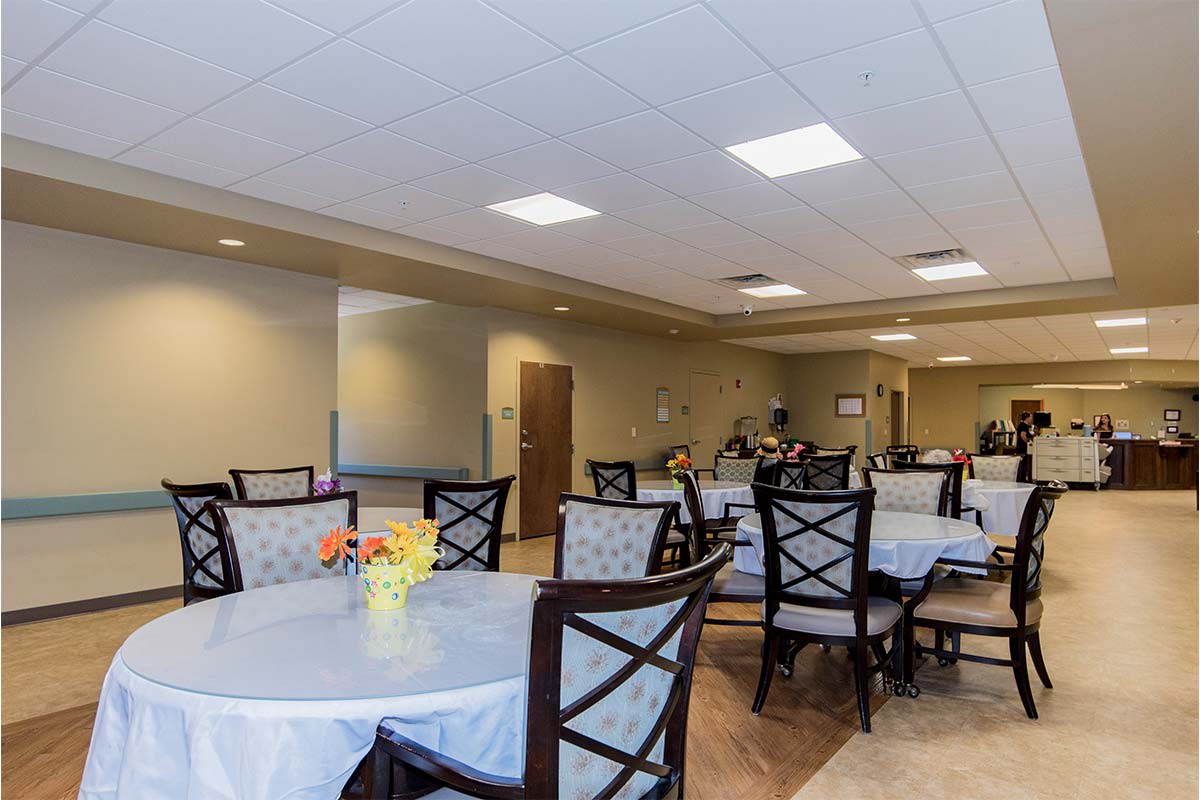 A well-lit dining area with tables and chairs arranged neatly.