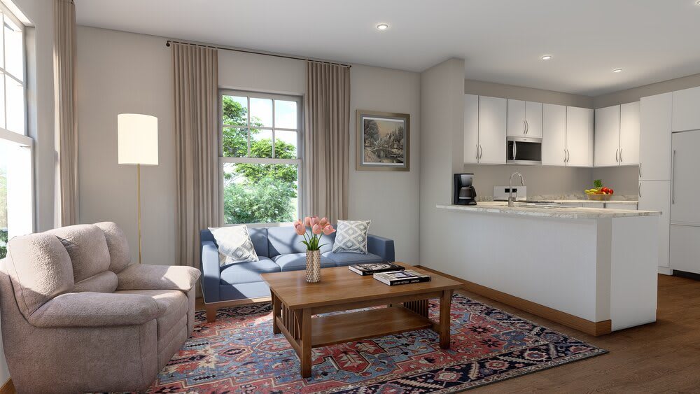 A cozy living room with a sofa, coffee table, and a view into the kitchenette.