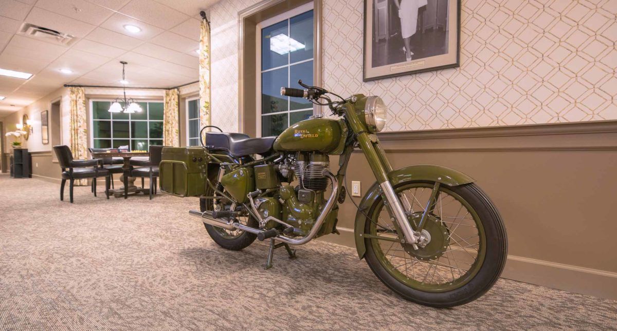 A vintage military green motorcycle on display indoors.