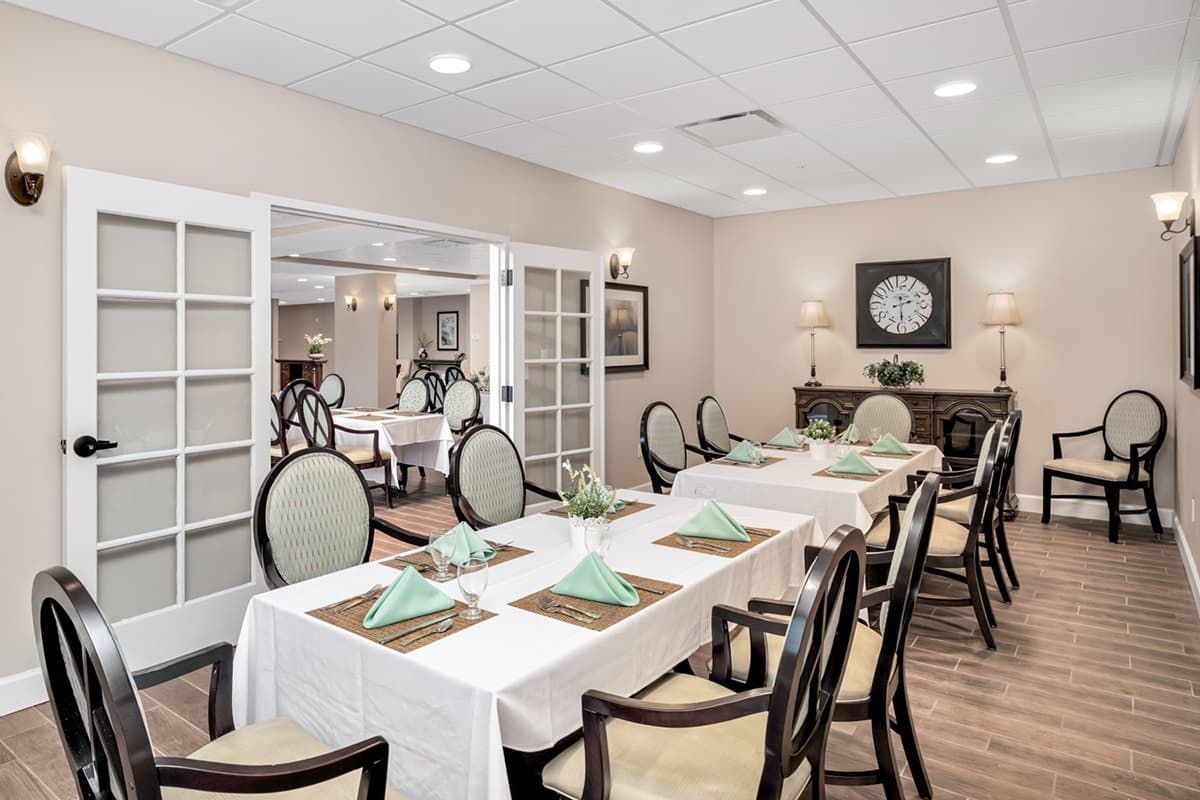 An elegant dining room with neatly arranged tables and chairs, featuring decorative table settings.
