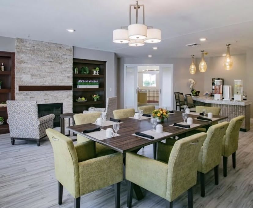 A modern dining area with a fireplace, featuring stylish furniture and elegant lighting.