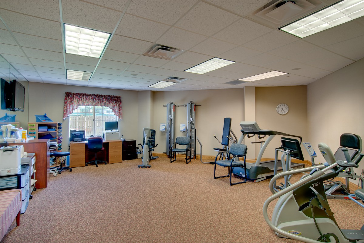 A fitness room equipped with exercise machines including treadmills and strength training equipment.