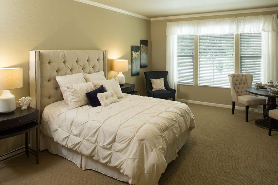 A cozy bedroom with elegant decor and a large window.