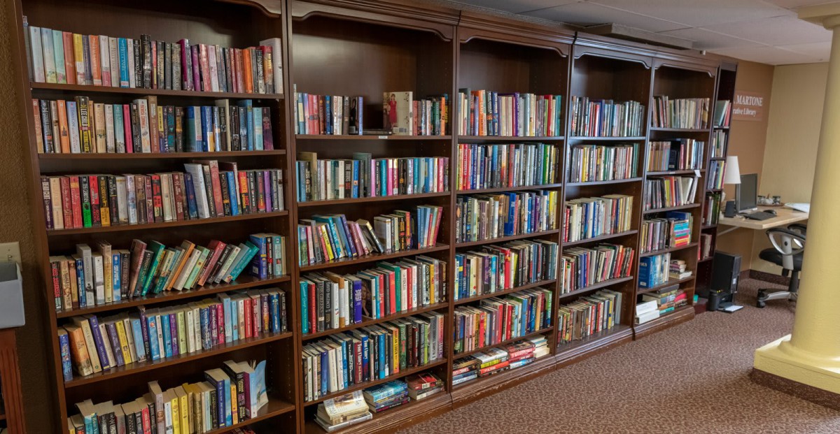 A neatly arranged bookshelf filled with a variety of books in a library.