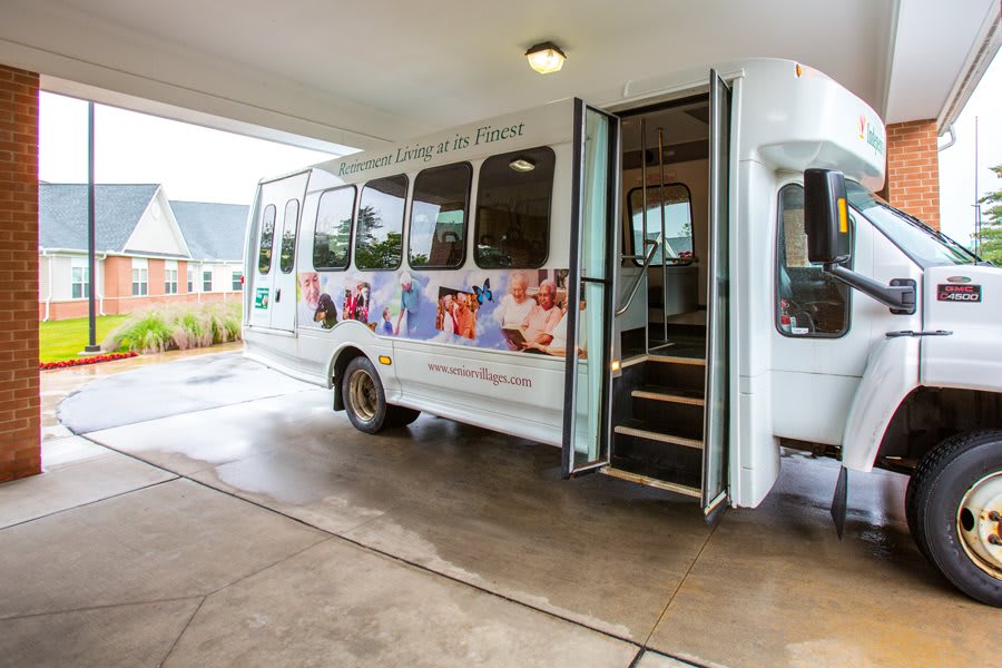 A community transport bus with open doors and images on its exterior.