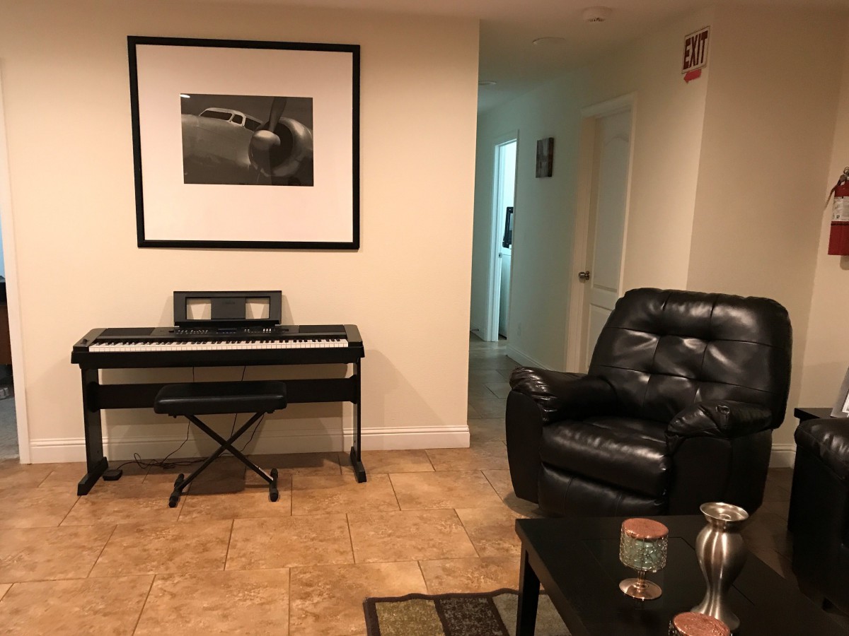 A cozy living room with a keyboard and armchair.