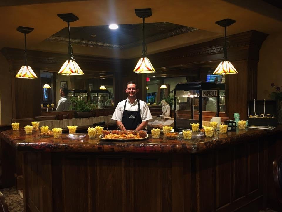 A chef stands behind a buffet counter at a restaurant, showcasing an assortment of dishes.