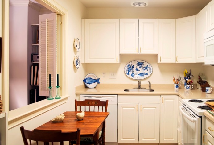 A cozy kitchen with a small dining area and classic white cabinets.