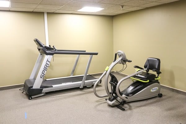An indoor fitness room featuring a treadmill and additional exercise equipment.