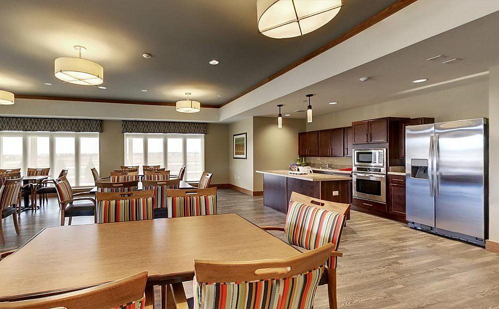 A modern dining area and kitchen with wooden furniture and stylish lighting.