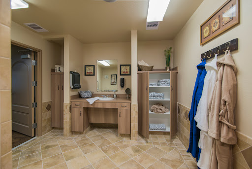 A well-organized bathroom featuring a spacious vanity, shelves for storage, and warm lighting.
