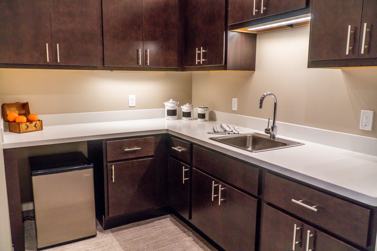 A modern kitchen with dark wood cabinets and a sleek countertop.