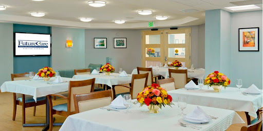 A beautifully arranged dining room with elegantly set tables and vibrant floral centerpieces.