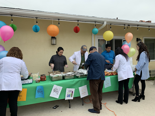 A gathering with a food table decorated for a festive outdoor event.