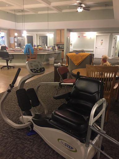 A cozy indoor space featuring exercise equipment alongside a dining area and comfortable seating.