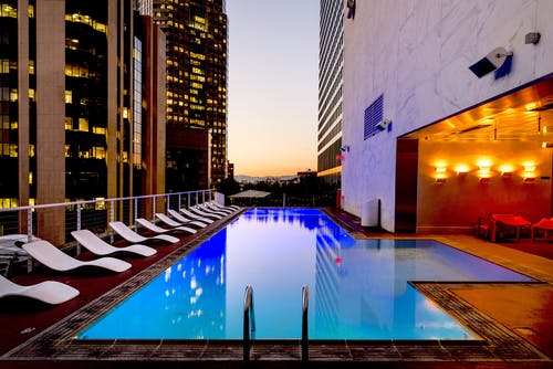 A stunning rooftop pool overlooking a vibrant city skyline at sunset.