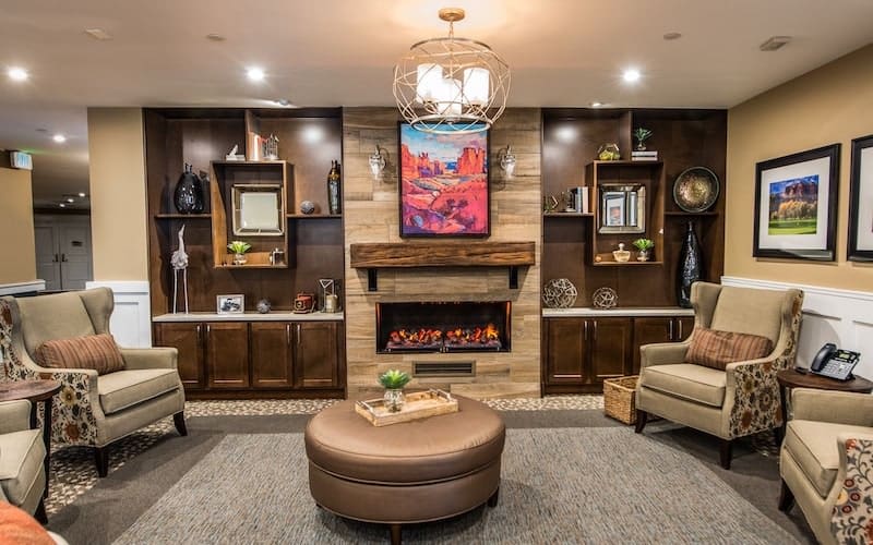 A cozy living room with modern furnishings and a central fireplace.