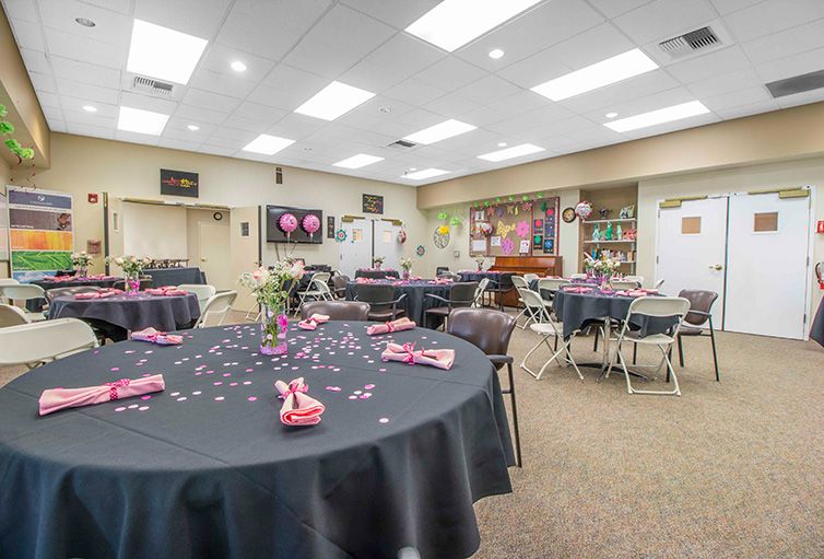 An elegantly decorated banquet room with round tables set for an event.