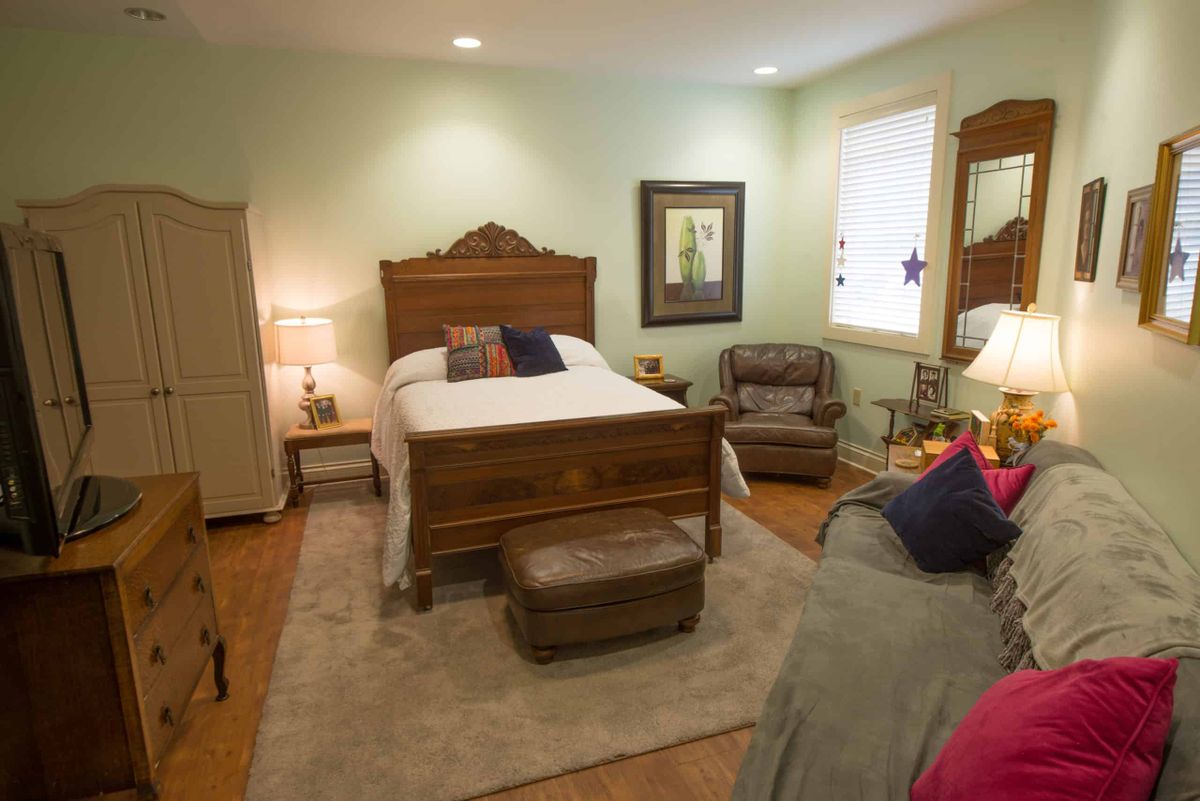A cozy bedroom with classic wooden furniture and soft lighting.