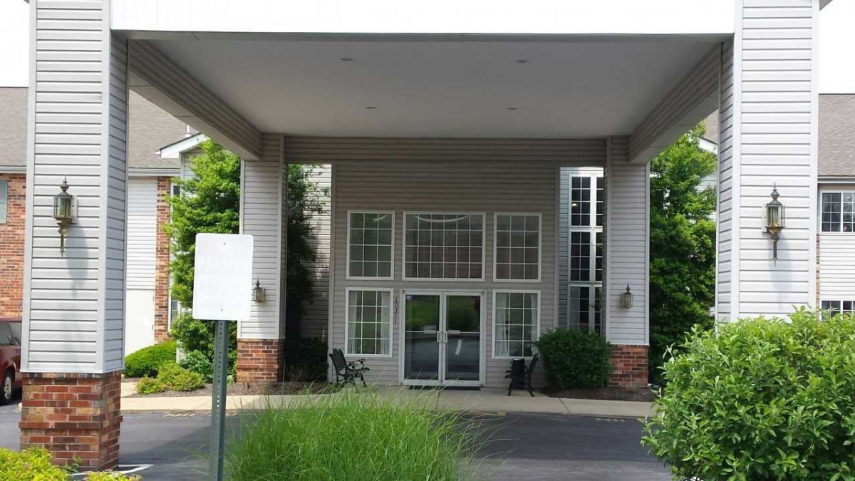 The image shows the entrance of a building with a canopy and large windows.