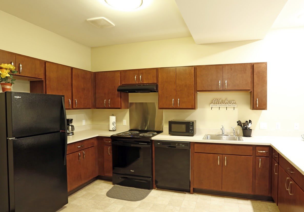 A modern kitchen with wooden cabinets and various appliances.