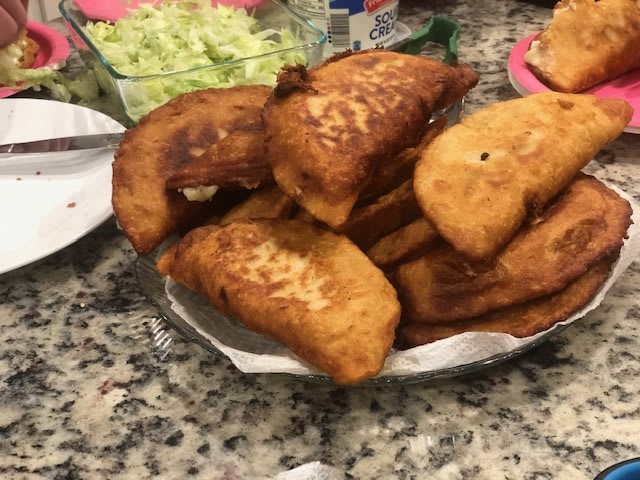 A plate of golden-brown fried empanadas ready to serve.