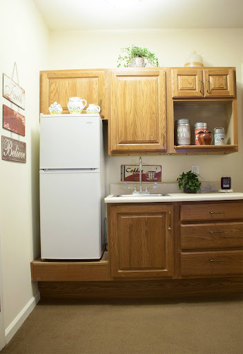 A cozy kitchen corner featuring a refrigerator and wooden cabinets.