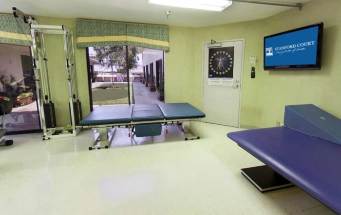 A clean and organized clinic examination room with treatment tables and a view of the outdoors.