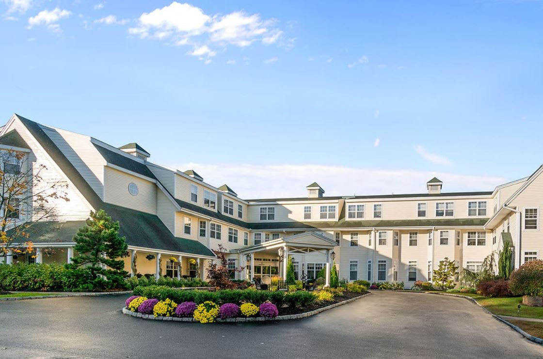 A charming hotel with a well-maintained entrance and landscaping under a clear blue sky.