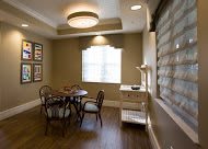 A cozy dining area with a table and chairs, complemented by warm lighting and window coverings.