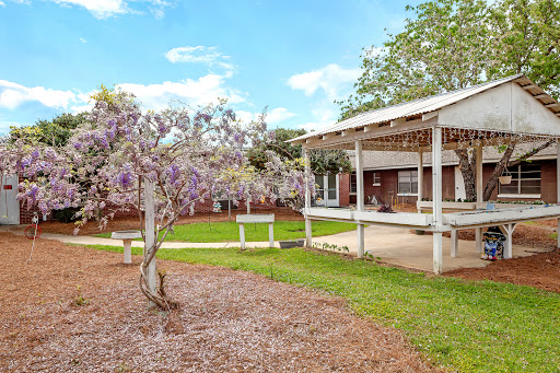 A charming house with a lovely garden, featuring blooming flowers and a spacious patio.
