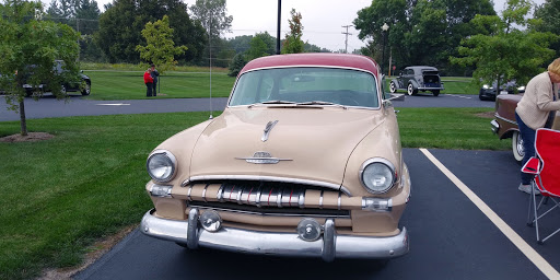 A stylish vintage car showcasing classic mid-century design with a golden body and red roof.