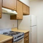 A compact kitchen with wooden cabinets and standard appliances.