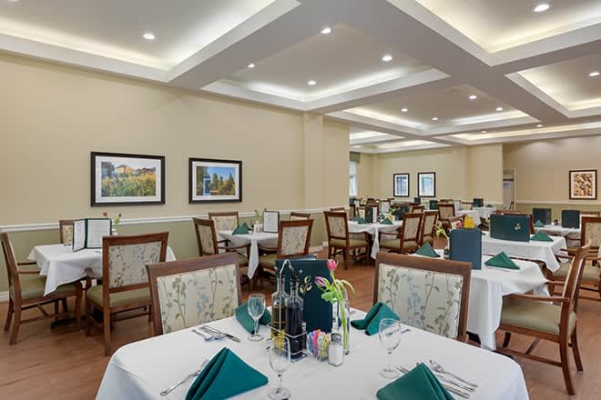 An elegant dining room with neatly arranged tables and chairs, featuring tasteful decor.