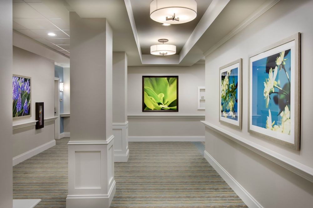 A modern hallway with framed artwork and stylish lighting fixtures.