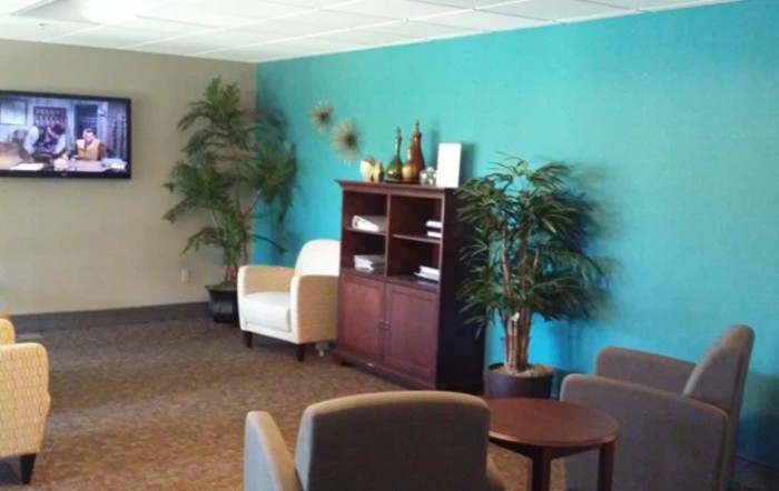 A cozy waiting room with comfortable seating and decorative plants.
