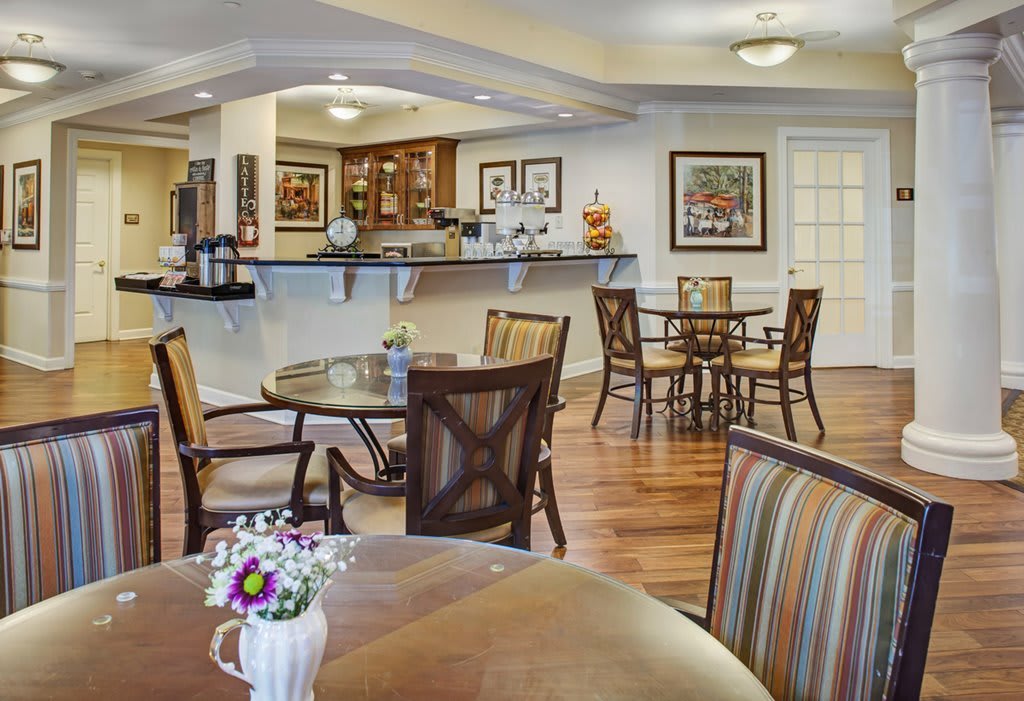 A cozy cafe with neatly arranged tables and chairs, featuring warm decor and inviting ambiance.