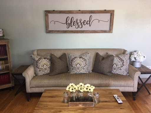 A cozy living room setup featuring a stylish sofa with decorative pillows and a charming centerpiece.