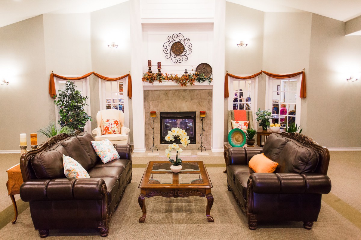 A cozy living room with elegant sofas facing a decorative fireplace.