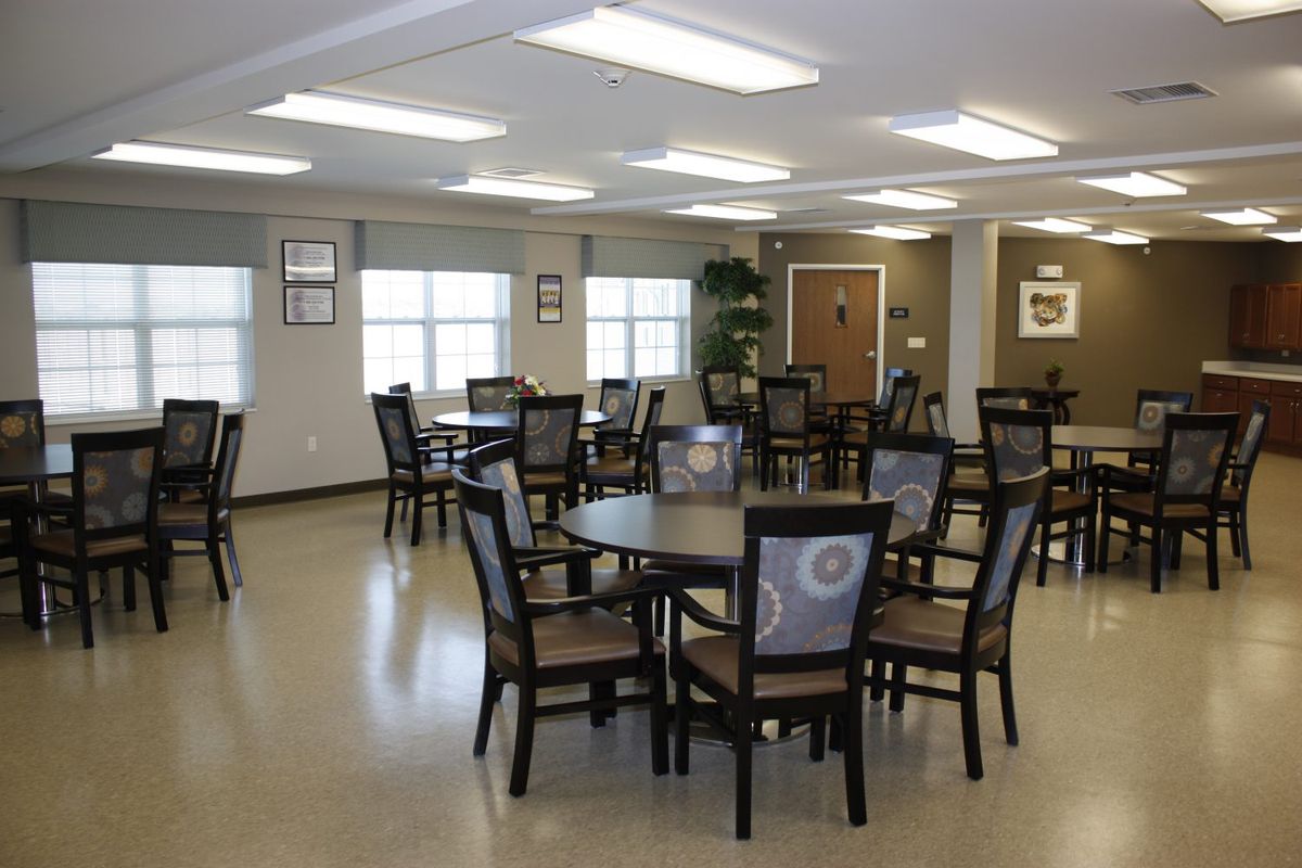 An empty dining room with multiple tables and chairs arranged neatly.