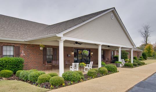 A cozy building with a covered porch and well-manicured landscaping.