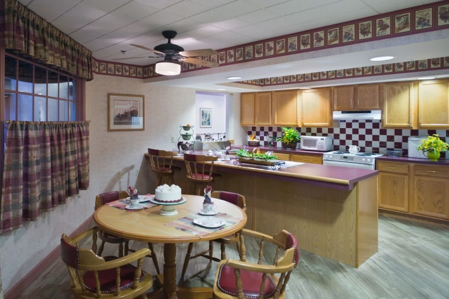 A cozy kitchen and dining area with wooden furniture and a decorative border.