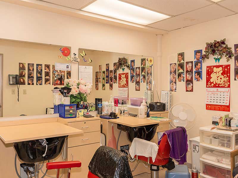 An interior view of a hair salon with mirrors, chairs, and various photos decorating the walls.