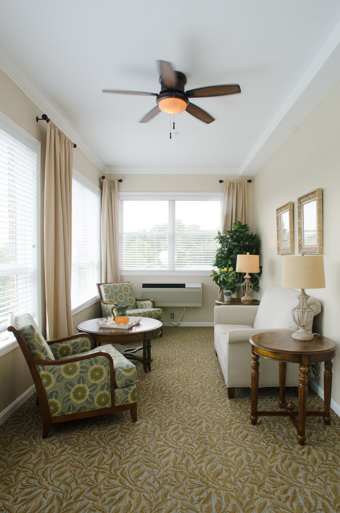 A cozy living room with comfortable seating, a coffee table, and large windows allowing natural light.